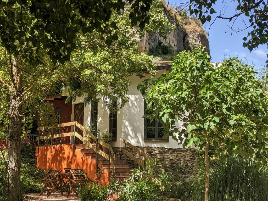 Casa blanca con balcón y árboles en La Molina - casas independientes en naturaleza excepcional en Setenil