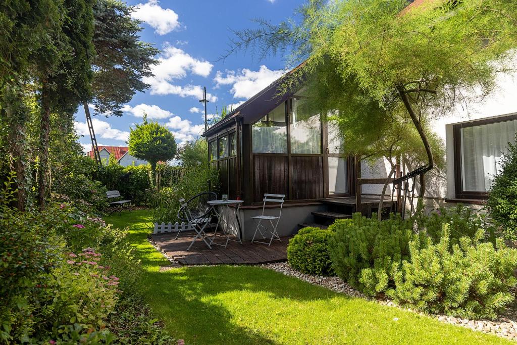 une cabine dans un jardin avec une table et des chaises dans l'établissement Małe Letnisko, à Puck