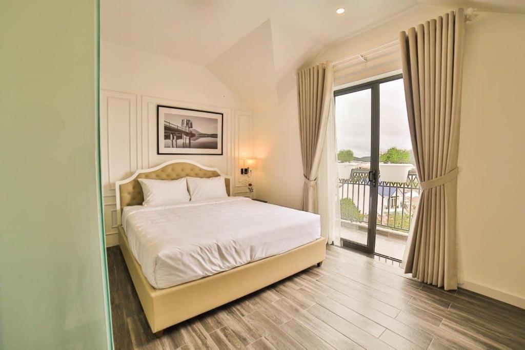 sypialnia z łóżkiem i dużym oknem w obiekcie MONACO HOTEL w mieście Khu Chi Lăng