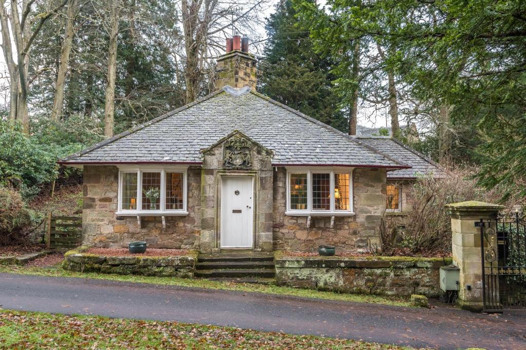 a small stone house in the middle of a street at Hideaway country cottage near Edinburgh in Penicuik