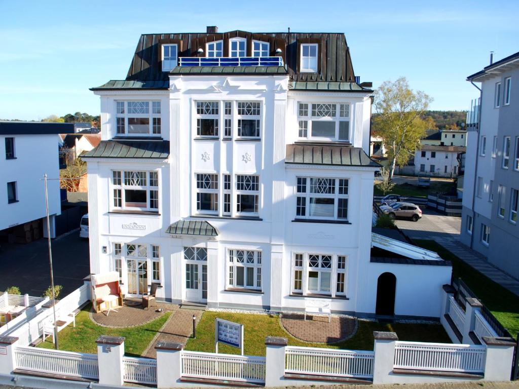 ein weißes Haus mit schwarzem Dach in der Unterkunft Hamburg App. 07 in Ahlbeck