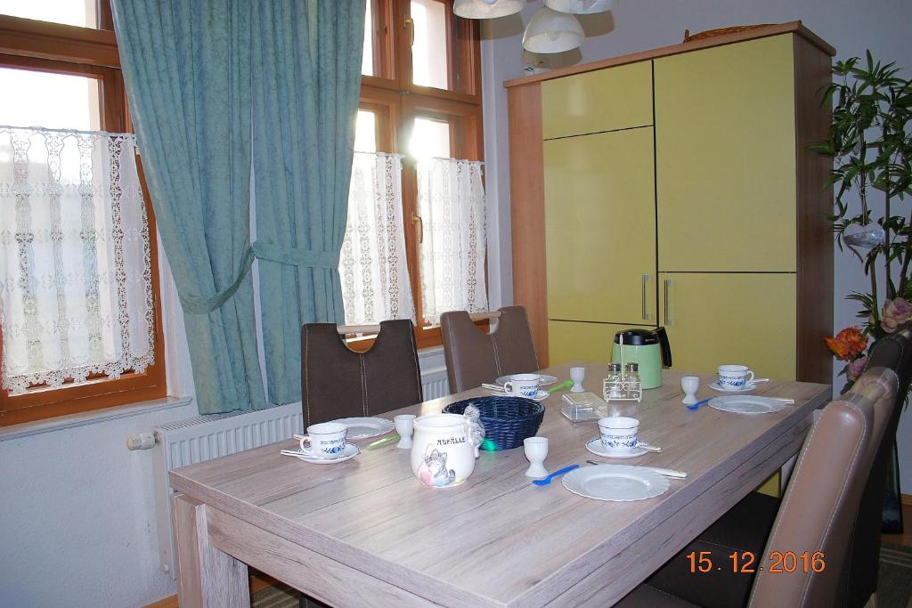 a dining room table with chairs and a wooden table with cups at Bellevue-App-14 in Ahlbeck