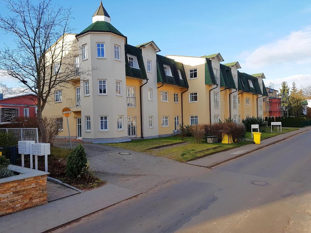 um grande edifício amarelo e branco numa rua em Feriendomizil-Goethestr-App-12 em Ahlbeck