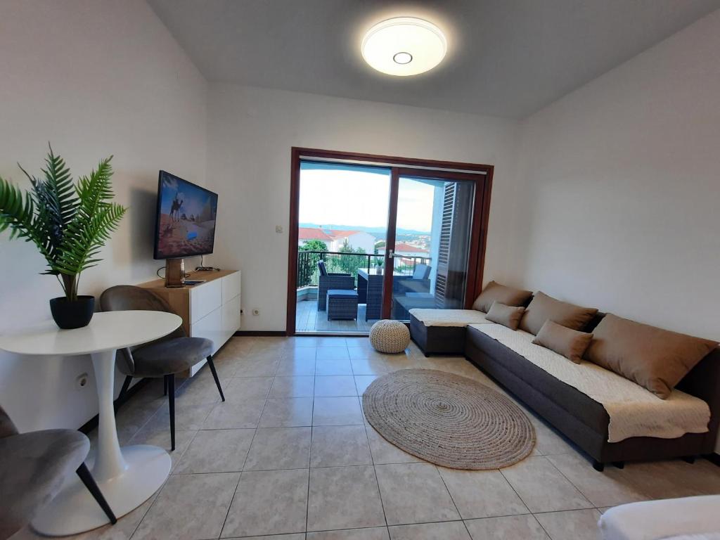 a living room with a couch and a table at TIZA Apartments in Vantačići