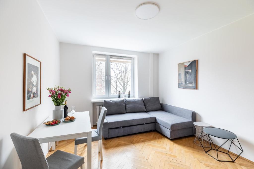 uma sala de estar com um sofá e uma mesa em P&O Apartments Gamerskiego em Varsóvia
