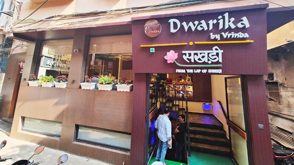 a restaurant with two people standing outside of it at Hotel Dwarika By Vrinda in Nāthdwāra