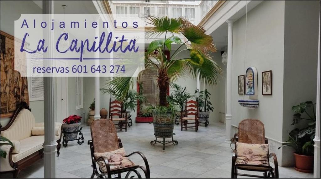 un vestíbulo con sillas y un cartel en un edificio en ALOJAMIENTO La CAPILLITA HABITACION CON BAÑO, en Sanlúcar de Barrameda