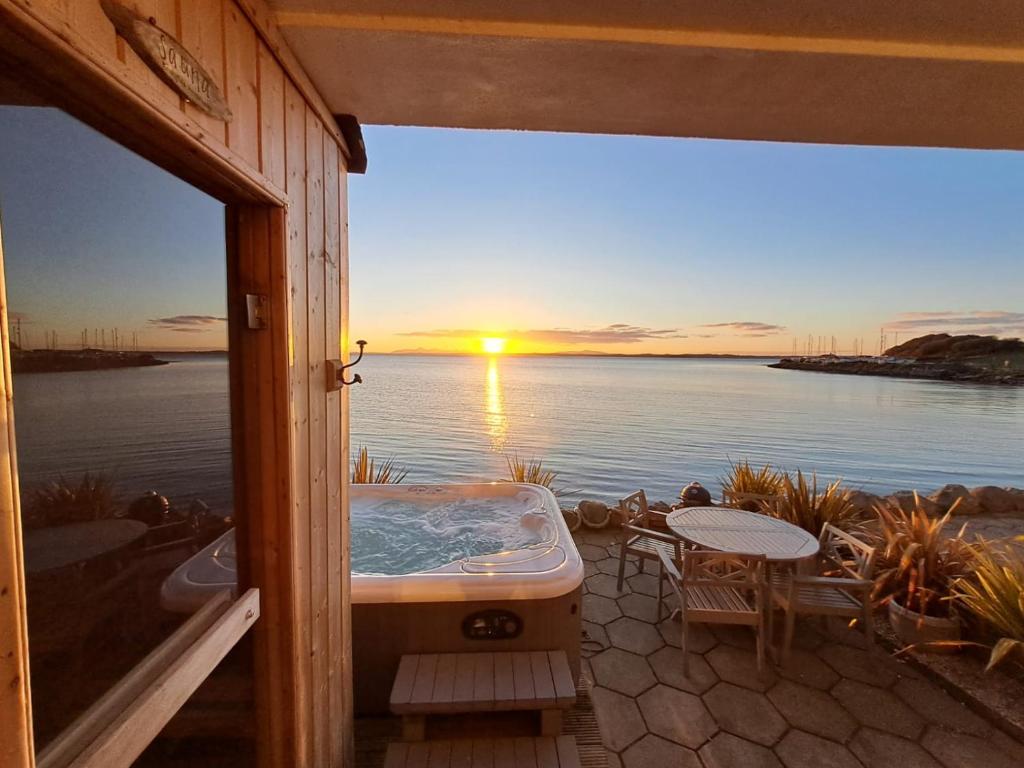 patio con vasca idromassaggio e vista sull'oceano di Relaxing cottage with spectacular view, Sauna and Spa Pool a Kircubbin