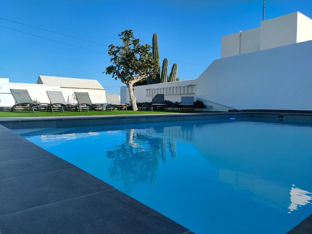 une piscine en face d'un bâtiment dans l'établissement Villa Carpe Diem en Puerto del Carmen, à Puerto del Carmen