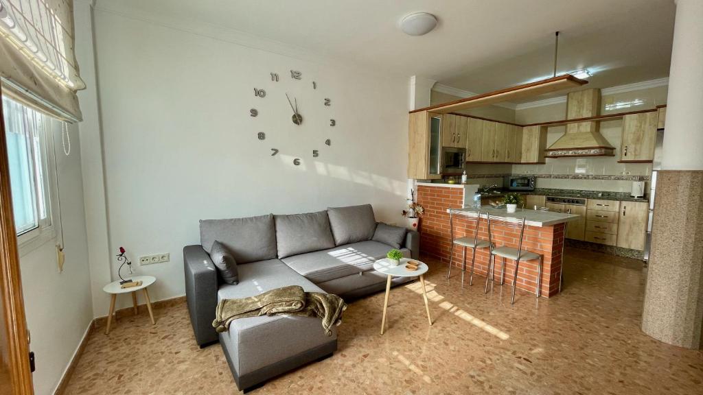 sala de estar con sofá y cocina en Palacio de Ferias apartamento, en Málaga