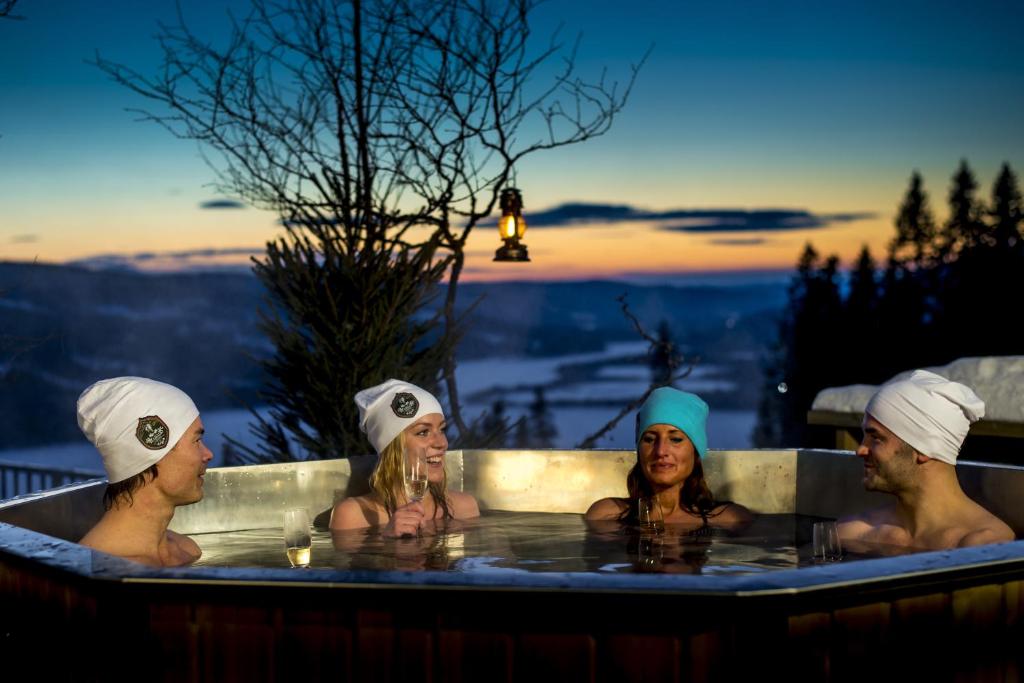 a man and a woman sitting in a pool of water at Hotell Fjällgården Ski-In Ski-Out in Åre