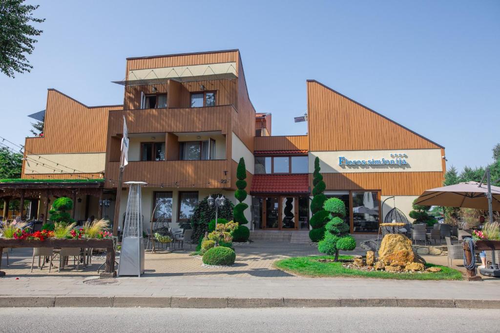 un grande edificio con molti tavoli e alberi di Floros Simfonija a Šventoji