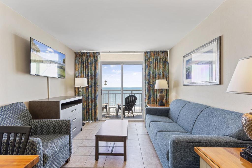 - un salon avec un canapé et une télévision dans l'établissement 2BR Beachfront Condo w Pools - Atlantica Towers Condo, à Myrtle Beach