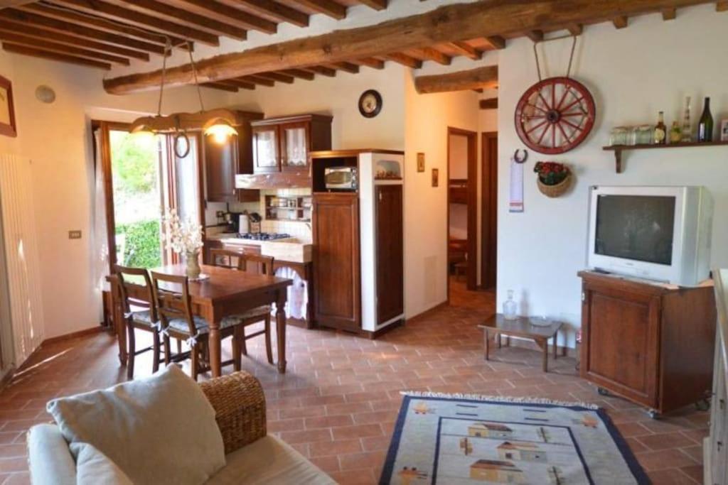 sala de estar con mesa y cocina en Cuore della Toscana en Radicondoli