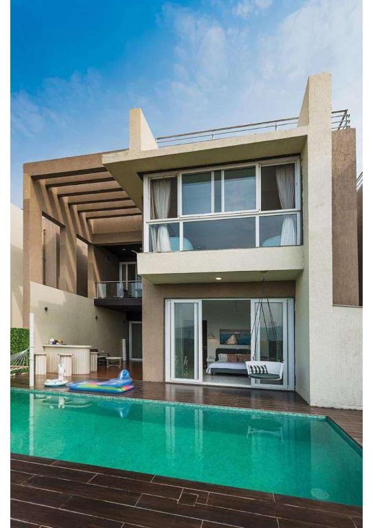 una casa con piscina frente a ella en Grey villa pure veg 4BHK, en Lonavala