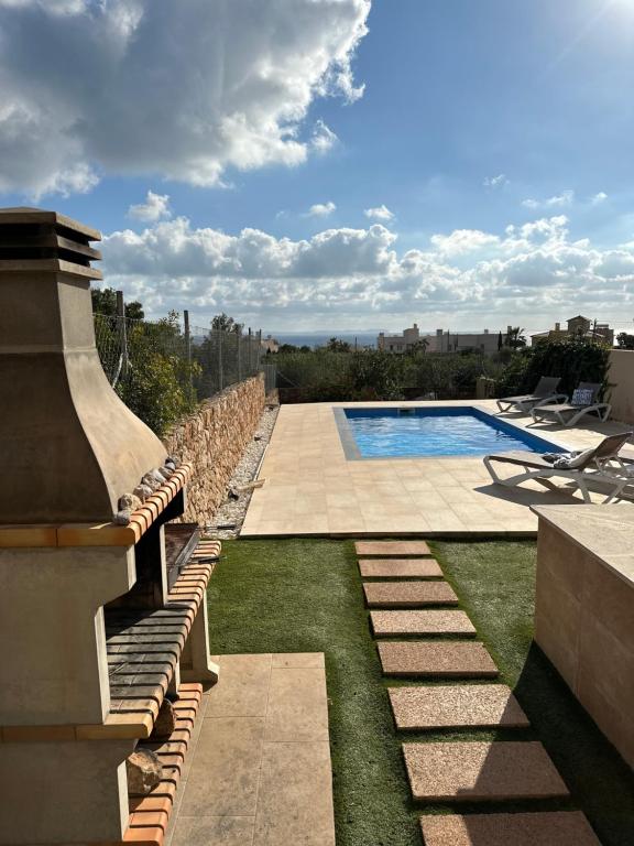 um quintal com uma piscina e uma varanda em Casa Mirador - Bonita casa pareada em Cala Pi