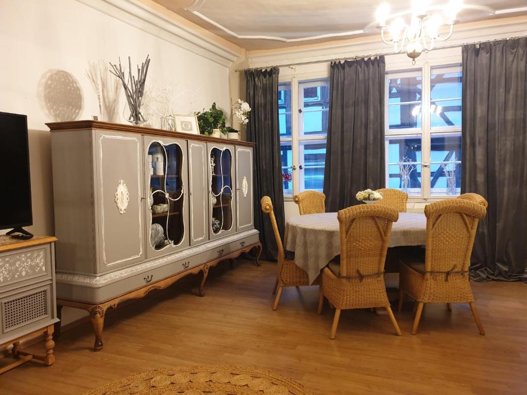 a dining room with a table with chairs and a dresser at Stillvolle Designwohnung im historischen Zentrum in Stolberg