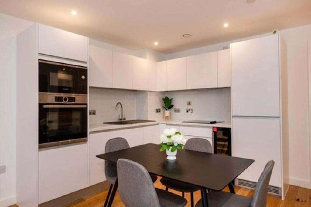 a kitchen with a table and chairs and a kitchen with white cabinets at 1 Bed In Birmingham City Centre in Birmingham