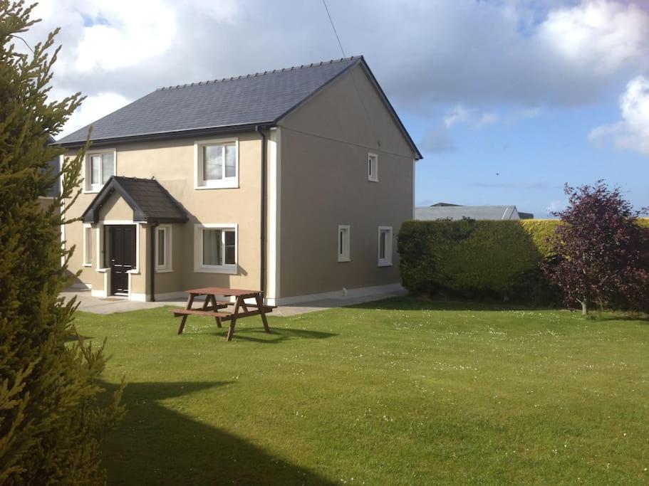 a house with a picnic table in the yard at Island Winds Along The Atlantic Way in Killala