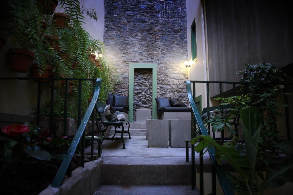 a room with a stairway with chairs and plants at 29 Madeira Hostel in Funchal