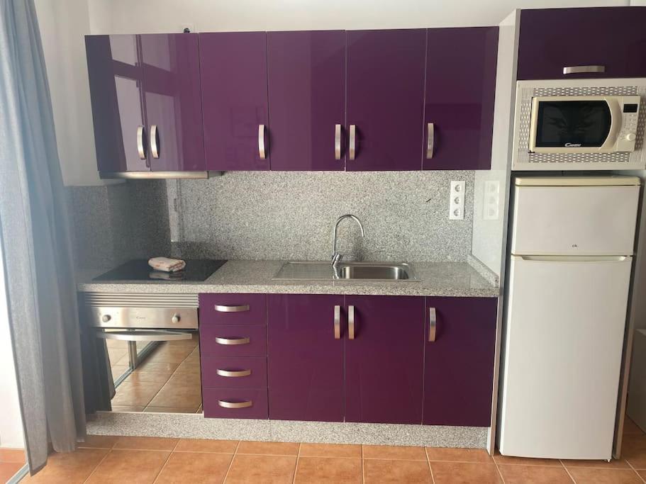a kitchen with purple cabinets and a sink and a microwave at VV VELERO in Puerto de Mogán