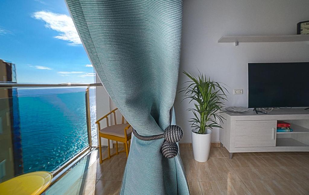 Una sala de estar con una ventana con vista al mar. en Maspalomas,Flipper, en Maspalomas