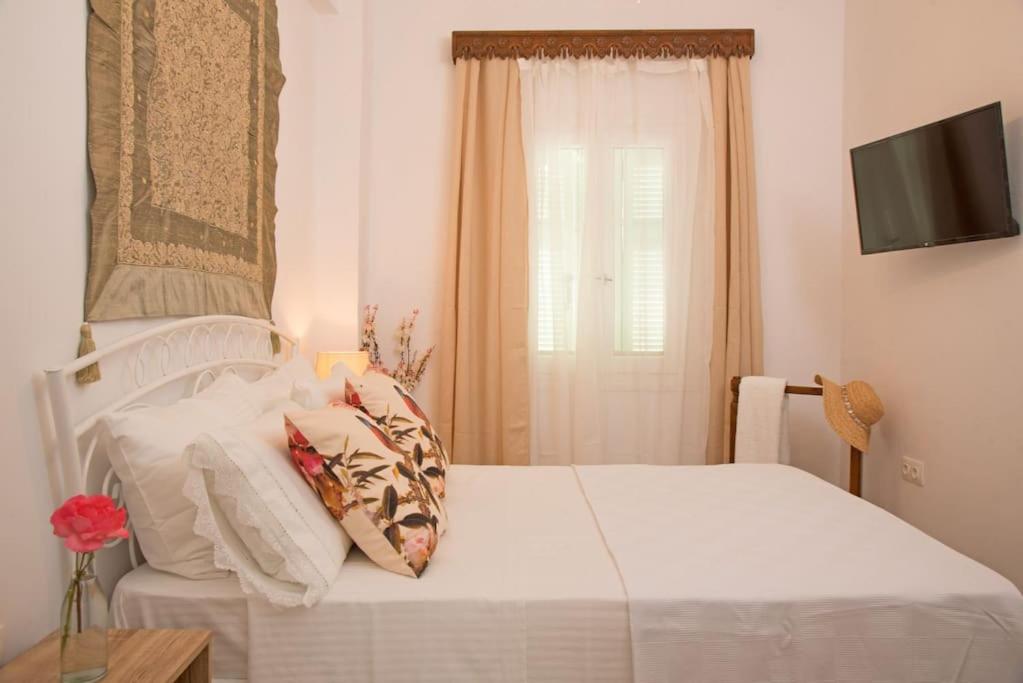 a bedroom with a white bed and a window at Katoi House - Central Skyros Village in Skiros