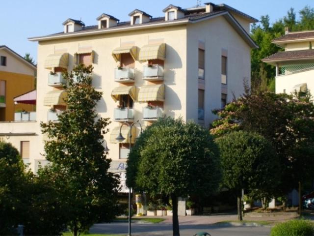 塔比亞諾的住宿－阿爾伯格馬倫吉酒店，一座带阳台的大型建筑,前面有树木