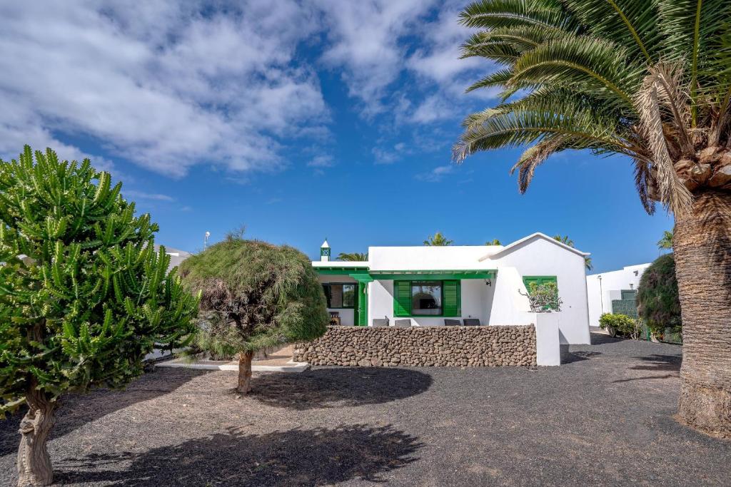 una casa con palmeras delante en VV Tamia by HH, en Playa Blanca