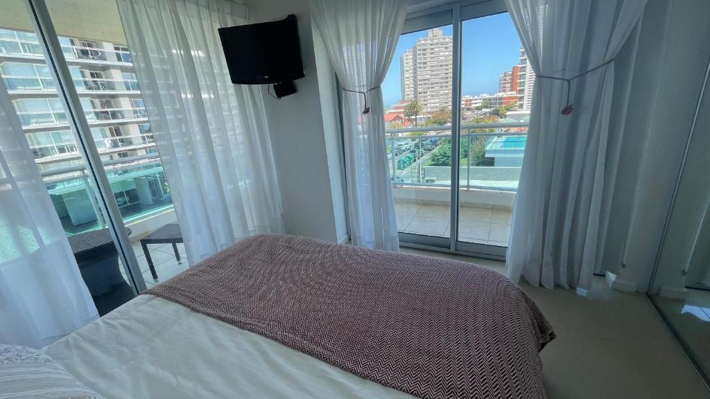 1 dormitorio con cama y vistas a la ciudad en Punta del Este, Sol y Luna II, Departamento 301, en Punta del Este