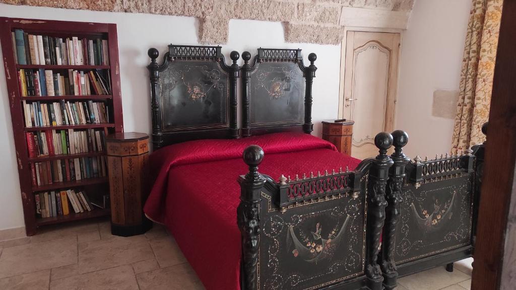 - une chambre avec un lit noir et une couverture rouge dans l'établissement La Controra, à Galatina