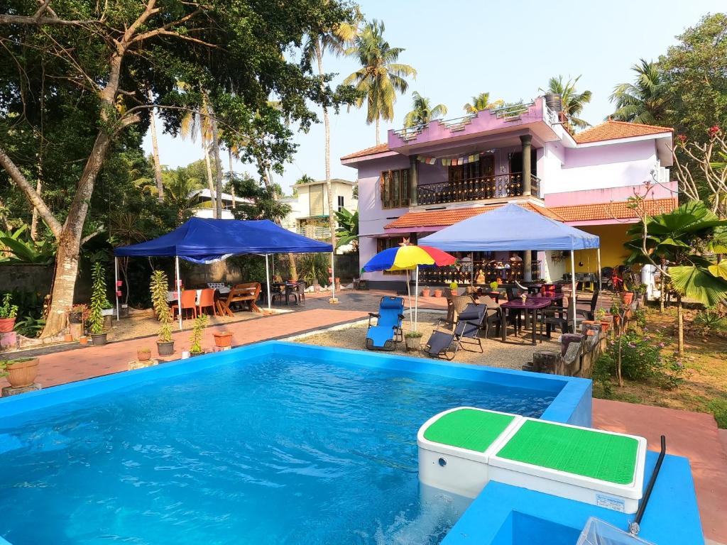 a swimming pool in front of a house at Casa Eva Luna Ayuryoga Retreat in Varkala