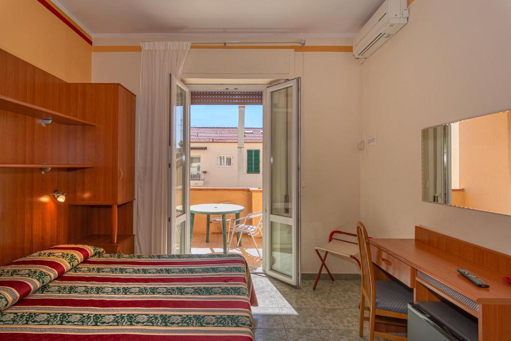 Habitación de hotel con 2 camas y balcón en Hotel Dolly, en Viareggio