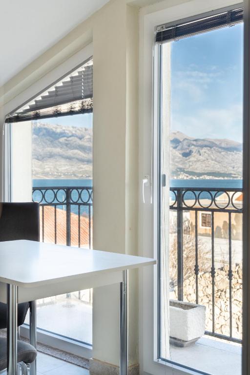 a room with a table and a view of the ocean at Apartments Delic in Ražanac