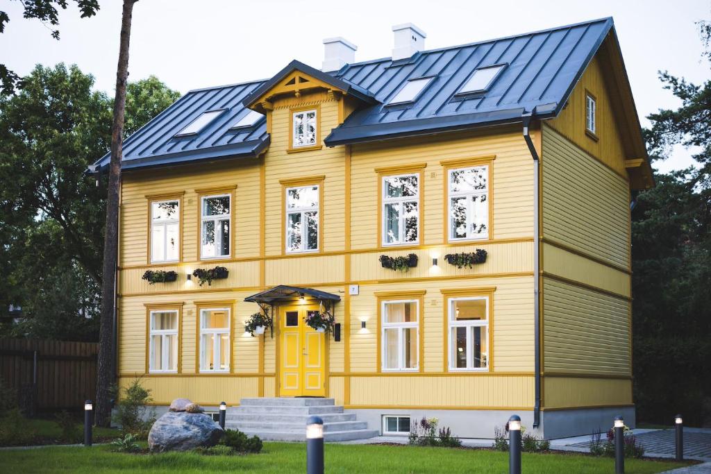 une maison jaune avec un toit bleu dans l'établissement Lenderi Villa Luxury Apartments with Sauna, à Tallinn