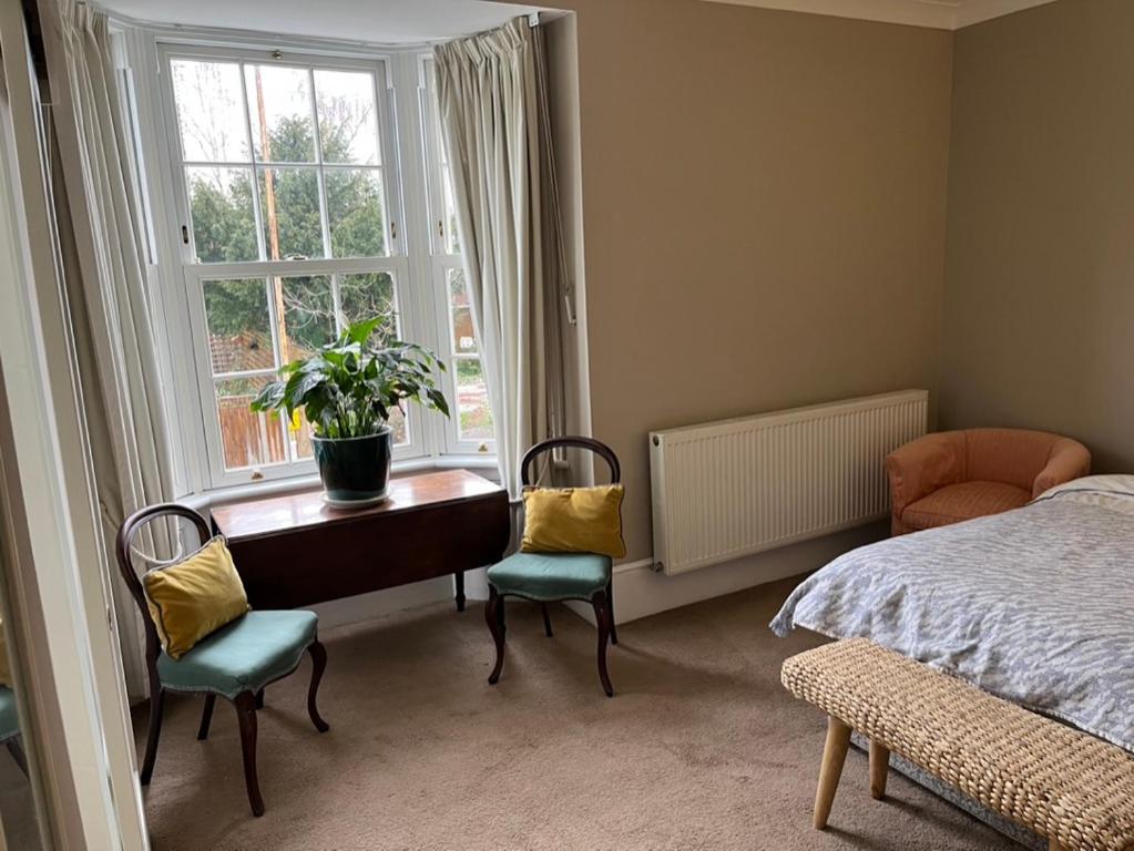 1 dormitorio con escritorio, sillas y ventana en Pilgrims Retreat en Kent