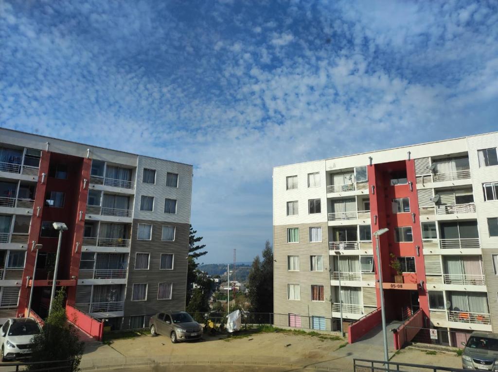 2 immeubles d'appartements avec des voitures garées dans un parking dans l'établissement ACOGEDOR DEPARTAMENTO Constitución, à Constitución