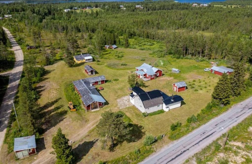 an aerial view of a house on a field with trees at Större gäststuga 