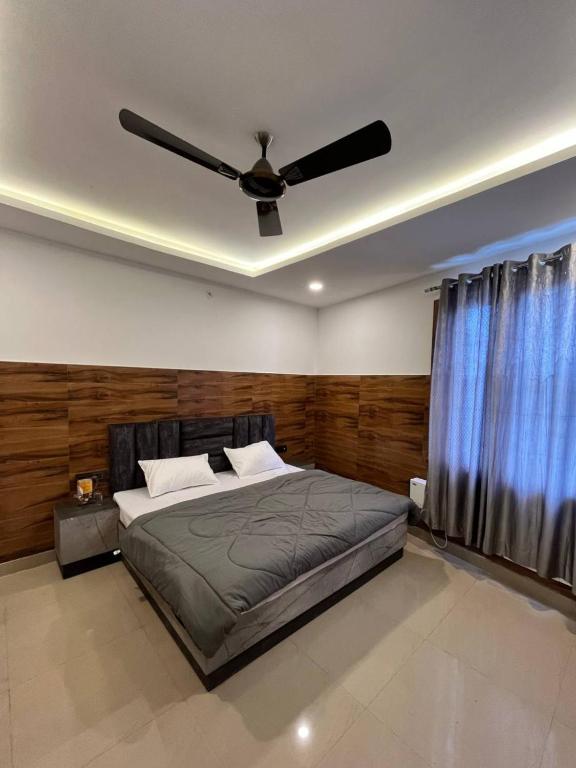 a bedroom with a bed and a ceiling fan at Hotel Shanti Residency in Katra