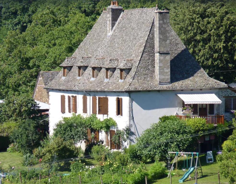 a large white house with a gray roof at La maison de Marie in Junhac