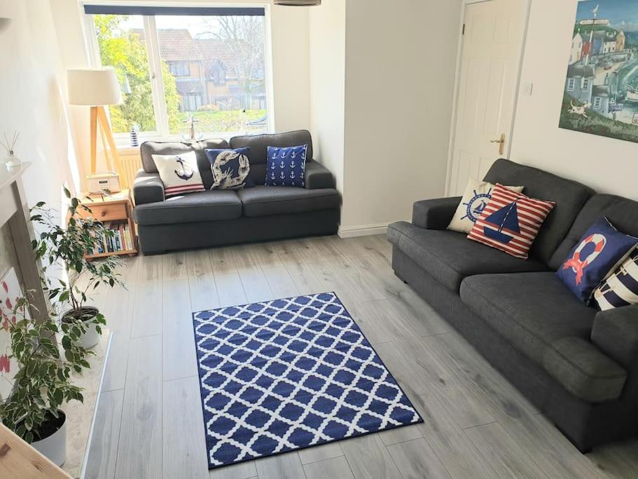 una sala de estar con 2 sofás y una alfombra en Nelson Heights - Perfect seaside retreat, Cromer, en Cromer
