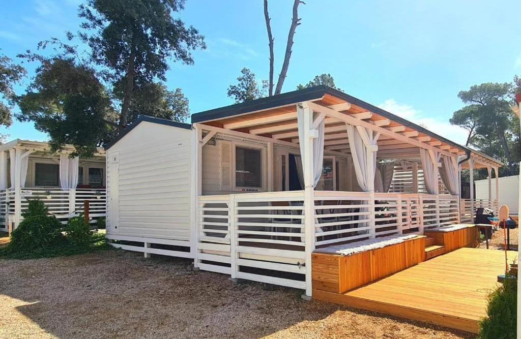 a white house with a porch and a deck at Blue Wave Mobile Home in Biograd na Moru