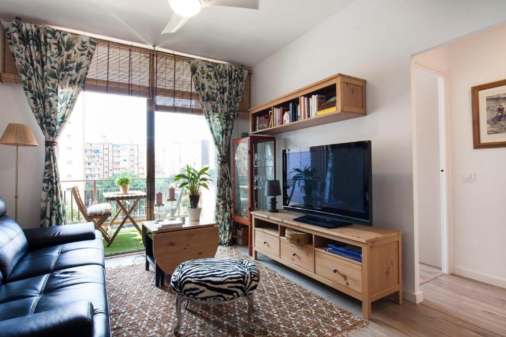 a living room with a couch and a television at Cozy Apartment near Fira Gran Via with AC in Hospitalet de Llobregat