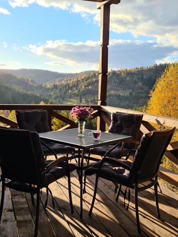 a table and chairs on a deck with a view at Villa Debryanets in Rozhanka Nizhnyaya