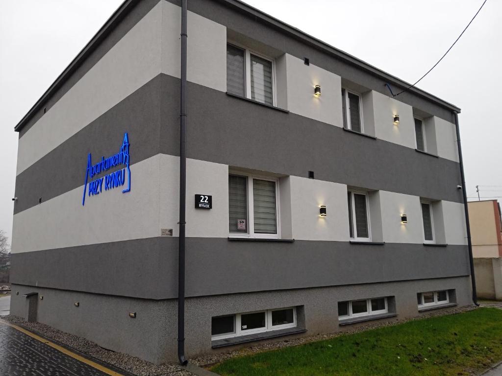 ein Gebäude mit einem blauen Schild auf der Seite in der Unterkunft Apartamenty Przy Rynku Gąsawa/Biskupin in Gąsawa