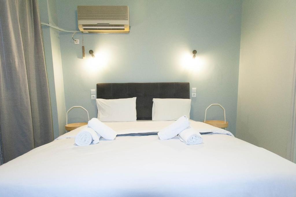 een slaapkamer met een groot wit bed met 2 kussens bij Athens City Themis 5 in Athene