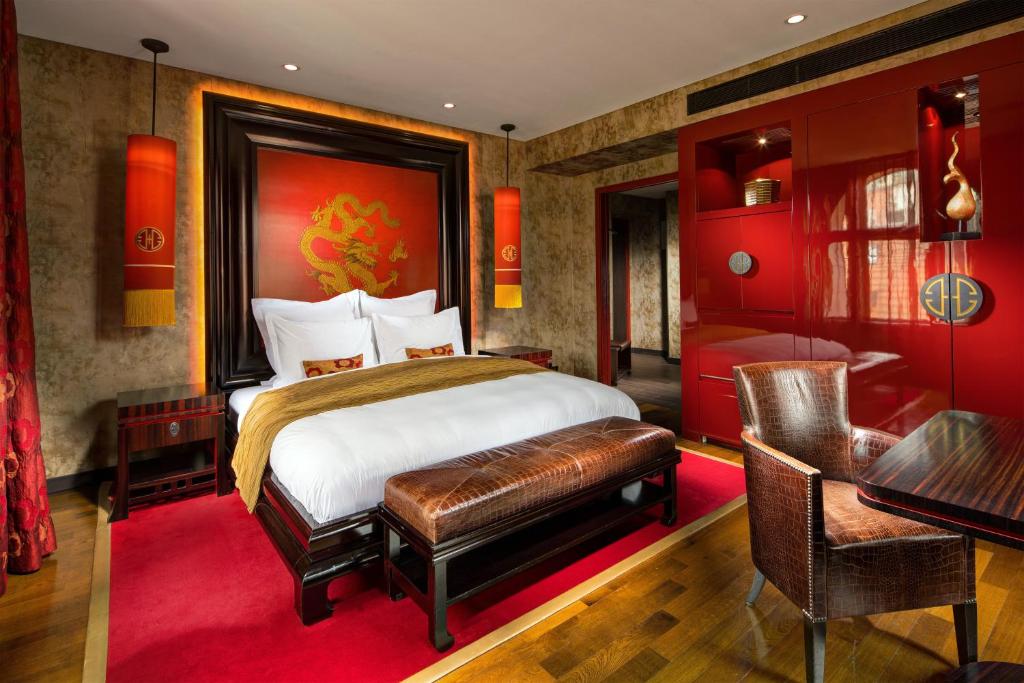 a bedroom with a bed and a desk and a table at Buddha-Bar Hotel Prague in Prague