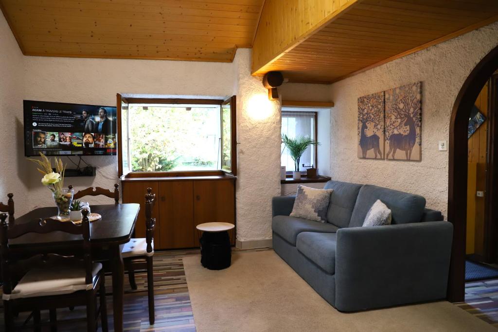 sala de estar con sofá y mesa en [Chalet Villa Maria] con Vista Montagne - Netflix en Mesocco