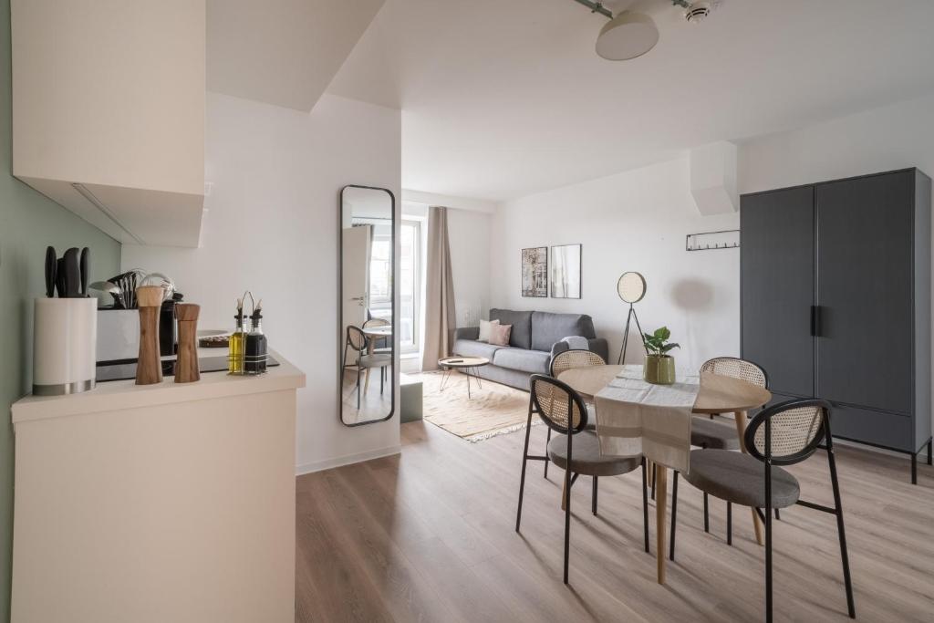 uma sala de jantar e sala de estar com mesa e cadeiras em limehome Saarbrücken Berliner Promenade em Saarbrücken