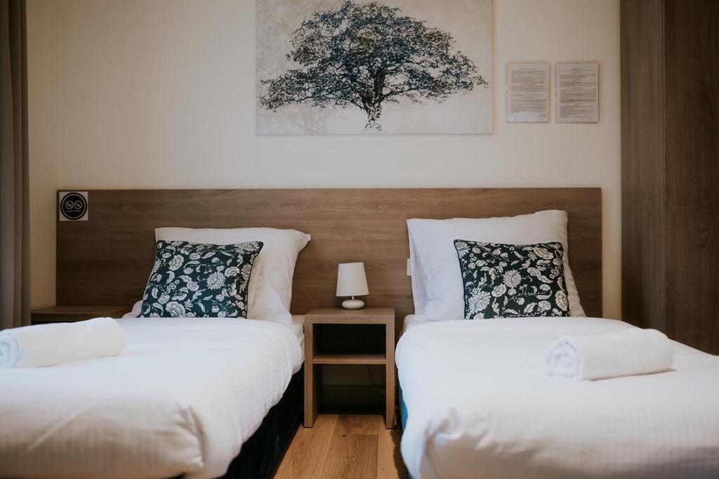 duas camas num quarto de hotel com lençóis brancos em Villa Garden em Oleśnica